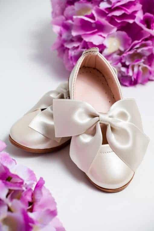 Pantofiori de botez albi, eleganți, cu o fundă mare din satin, perfect pentru evenimente speciale și botezuri, combinație de rafinament și delicatețe.