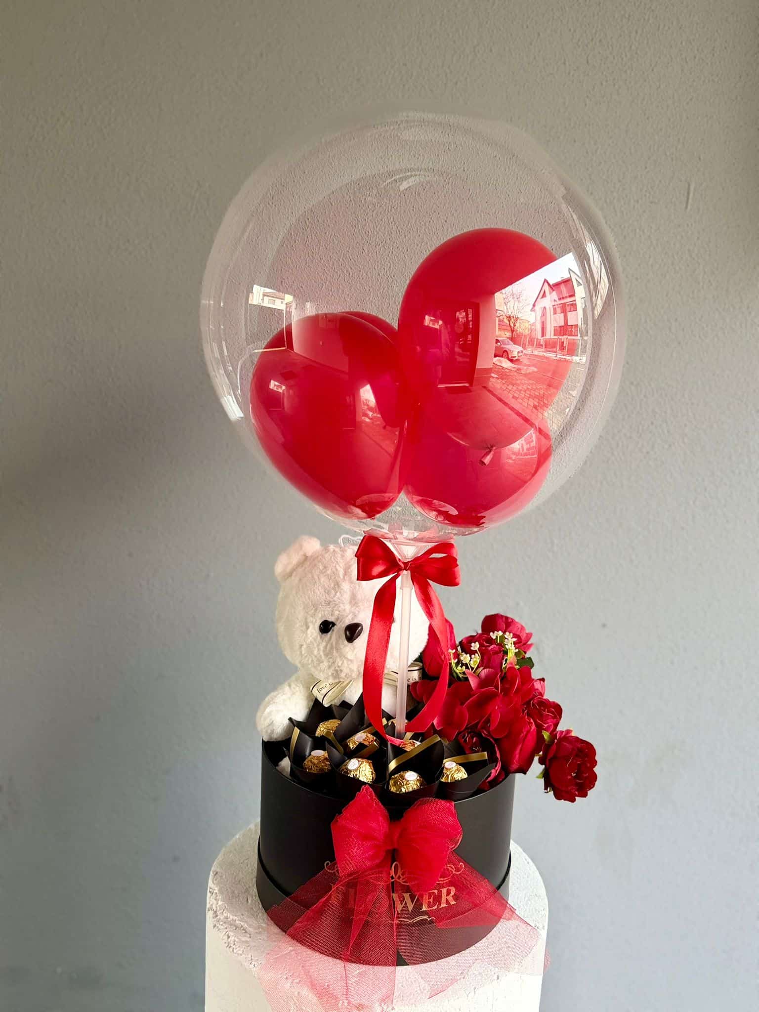 Aranjament cu baloane și flori Decor cu baloane, ursuleț de pluș, ciocolată și flori roșii pentru ocazii speciale.
