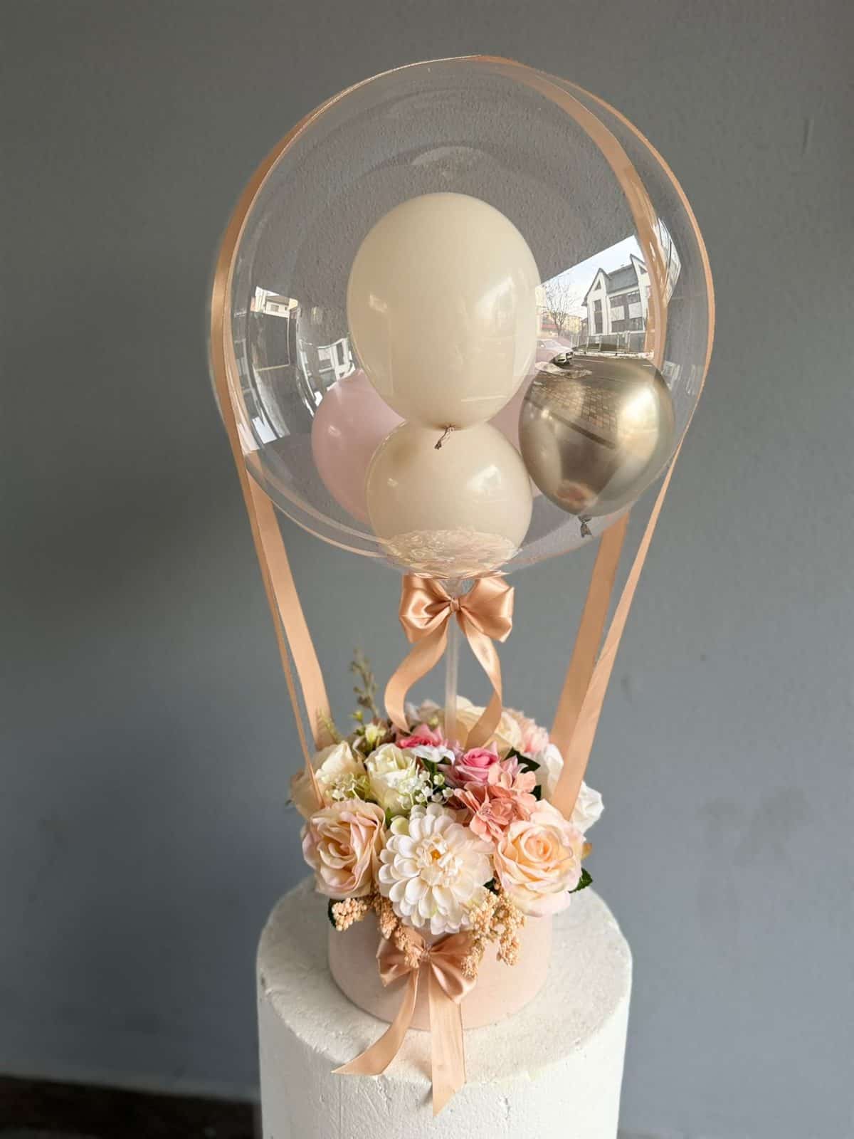 Aranjament cu balon transparent, baloane metalice și flori multicolore artificiale, decor pentru evenimente speciale.