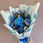 Arbore de flori albastru cu Stitch, decor pentru evenimente speciale. Buchet elegant cu flori și jucărie Stitch, perfect pentru tematici de poveste și aniversări.